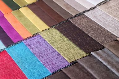 A sample book of many vibrant colors of fabric.